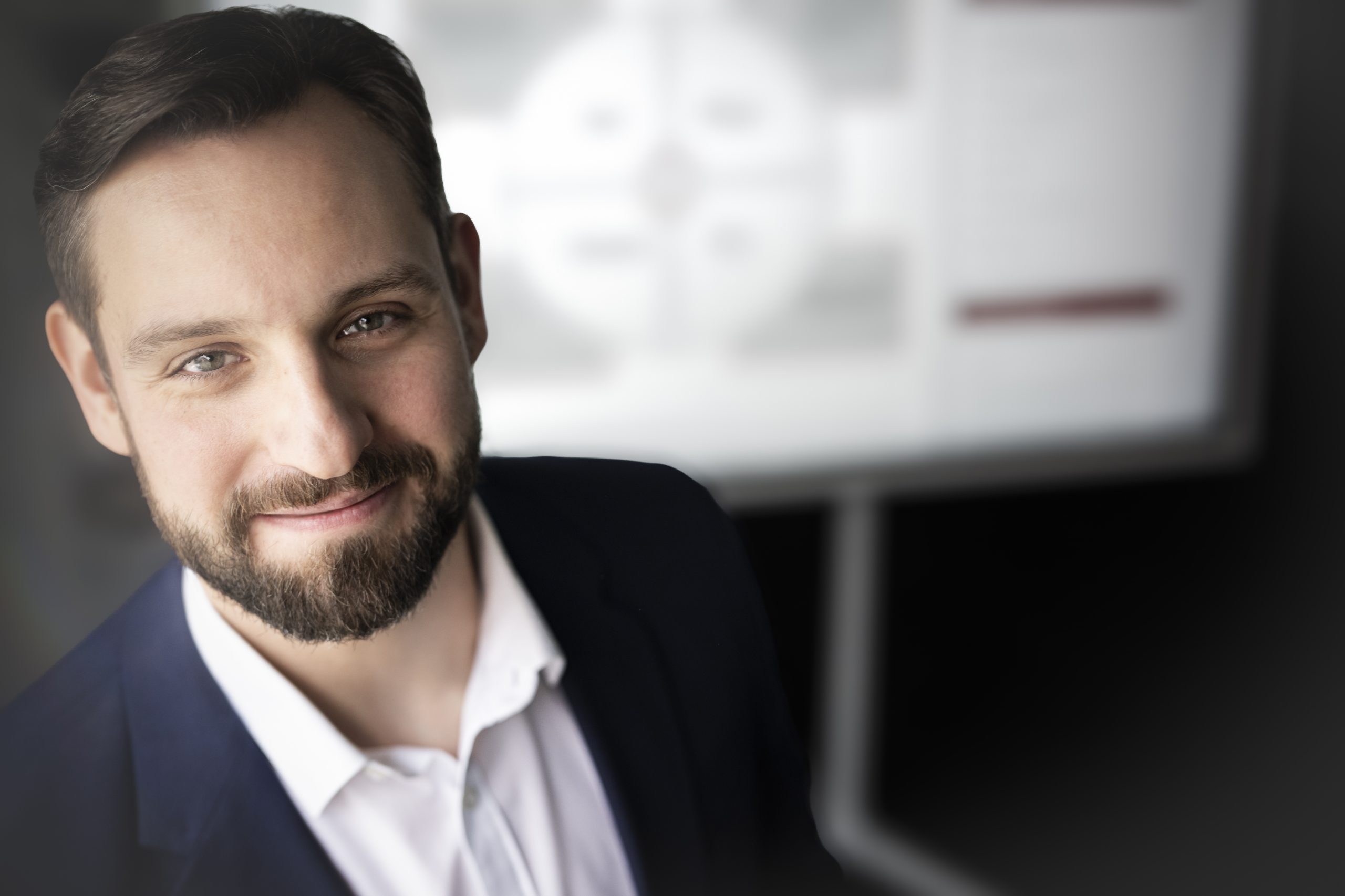 Portrait von Matthias Rücker. Im Hintergrund befindet sich ein Touchscreen